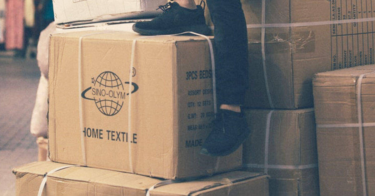 Man sitting on a stack of storage boxes. Featured image for blog post.