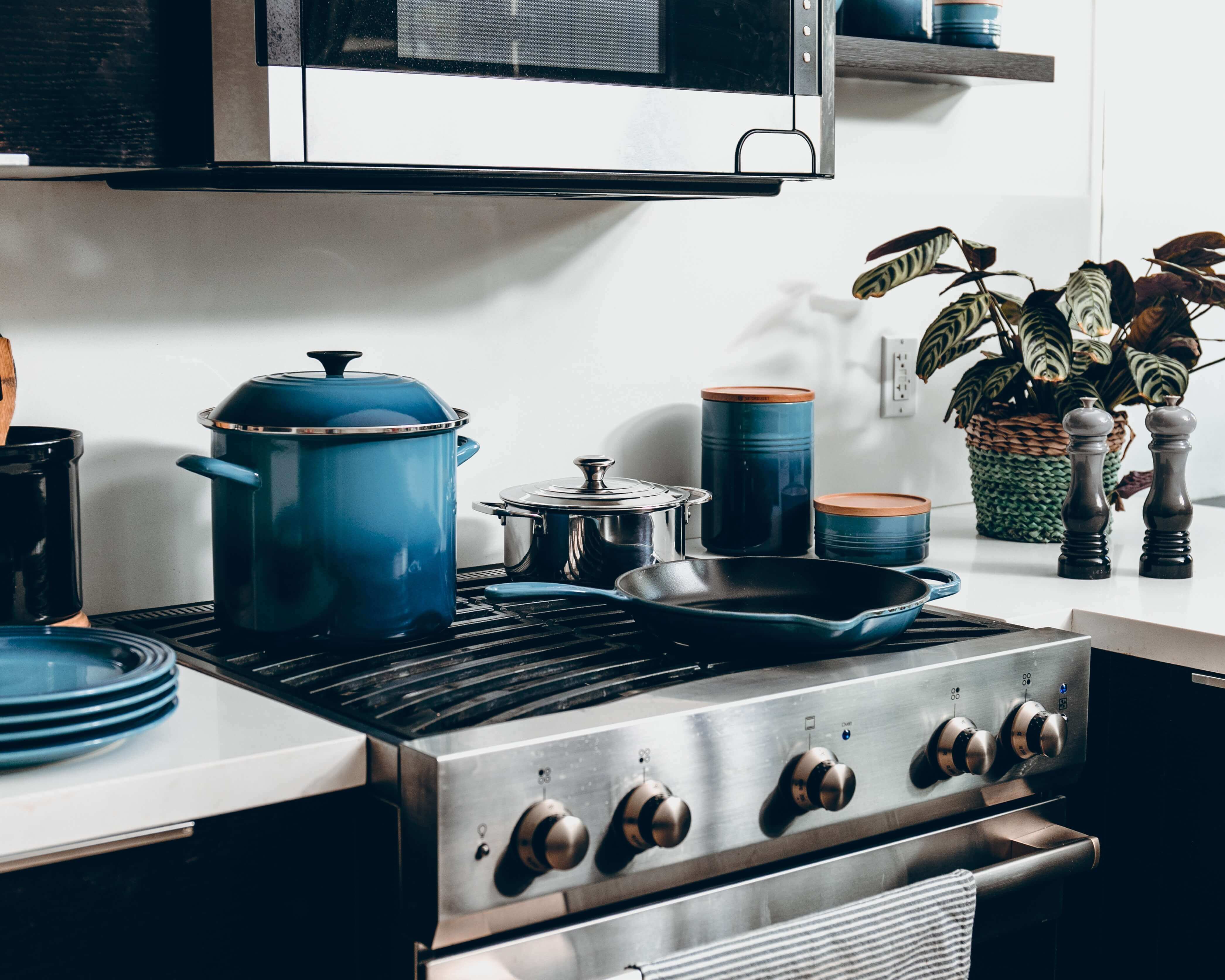 A beautiful kitchen with blue pots and pans.